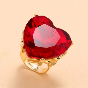 Macro shot of heart-shaped red gemstone set in a golden adjustable band ring