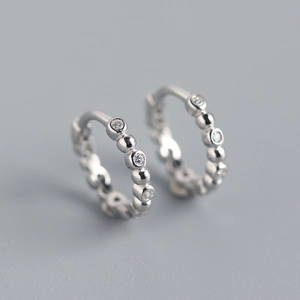 Macro shot of S925 sterling silver hoop earrings with bead accents and sparkling zircons