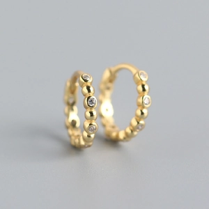 Close-up of gold S925 sterling silver hoop earrings with shimmering crystal accents