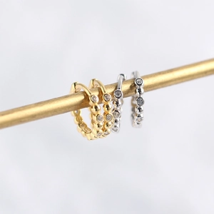 Close-up of gold and silver S925 sterling silver beaded hoop earrings with cubic zirconia