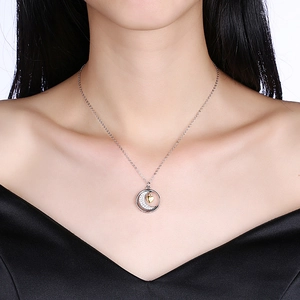 Close-up of S925 silver moon and gold heart pendant necklace worn by a female model