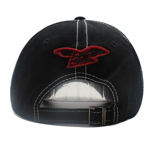 Detail of black denim baseball cap with white contrast stitching and red eagle embroidery