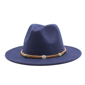 Close-up of navy wool fedora with a braided ethnic band and green bead ornaments