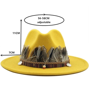 Detail of yellow wool fedora hat with bohemian feathers and decorative beads