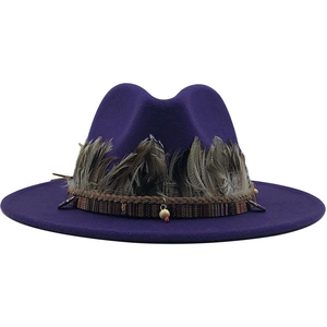 Detailed close-up of a purple felt fedora hat featuring ethnic bands and natural feathers