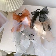 Flat lay of organza bow hair ties in orange, purple, gray, white, black and beige colors