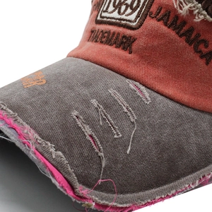 Macro shot of vintage 1969 embroidery and distressed brim on orange-grey baseball cap
