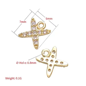 Mini ciondolo a croce dorata con zirconi con misure di 7mm x 6mm e peso di 0,1g