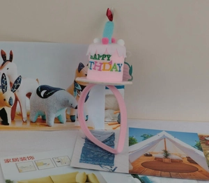 Pink plush birthday cake headband with Happy Birthday embroidery and blue candle detail