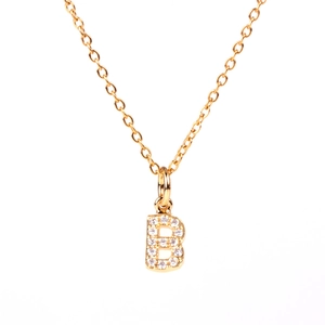 Macro shot of gold initial B pendant necklace with micro-pave cubic zirconia crystals