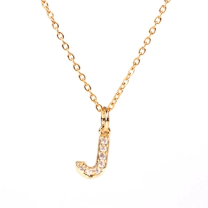 Detail of gold letter J pendant necklace with pavé cubic zirconia on cross chain