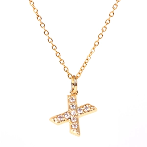 Macro shot of gold letter X pendant necklace featuring micro-set sparkling white zircons