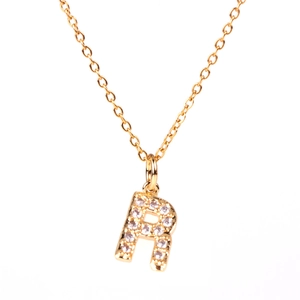 Close-up of gold letter R pendant necklace with pavé-set shimmering zircon stones