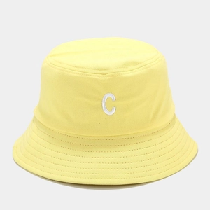 Dettaglio cappello pescatore giallo in tela con lettera C ricamata e cuciture rinforzate