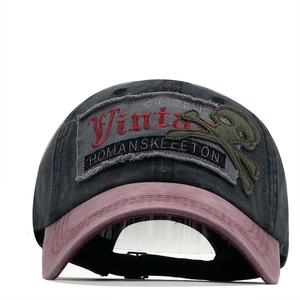 Close-up of vintage washed cotton cap with skull embroidery and distressed logo patch