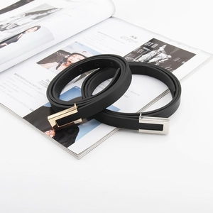 Detail of minimalist black slim belts with square gold and silver metal buckles