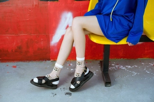 Detail of ultra-thin transparent socks with cat print paired with platform sandals