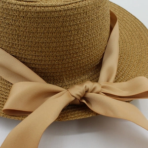 Summer straw boater hat with elegant flat top and decorative coffee satin ribbon bow