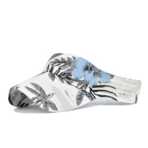 Detail of wide brim sun hat with blue tropical floral print and white fabric texture