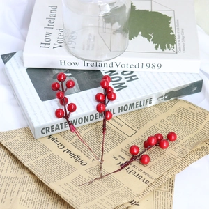 Artificial red berry stems for Christmas DIY decor on vintage books and kraft paper
