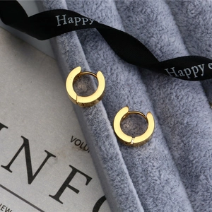 Polished titanium steel rose gold hoop earrings resting on a velvet jewelry display box