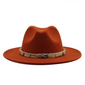 Close-up of orange wool fedora featuring a rope band with turquoise and scorpion charm