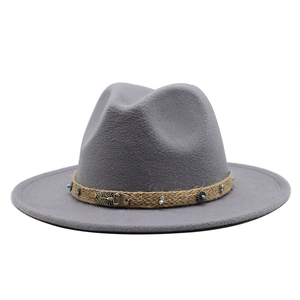 Detail of dark grey wool fedora featuring a woven band with vintage metal scorpion ornament