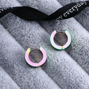 Macro shot of colorful rainbow titanium steel hoop earrings on soft grey velvet