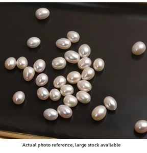 Macro shot of natural freshwater rice pearls in white-pink luster on black background