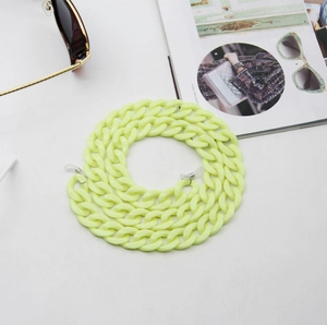Detail of neon yellow acrylic chunky eyeglass chain with silicone loops on magazine