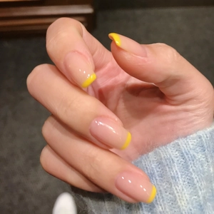 Minimalist French nude press-on nails with yellow tip design shown on hands