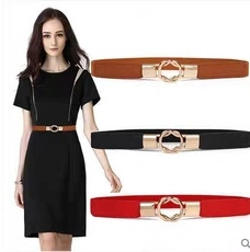 Detail view of interlocking gold metal buckles on elastic waist belts in brown, black, red