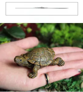 Gros plan d'une figurine de tortue miniature réaliste tenue en main pour le jardinage