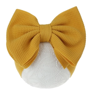 Close-up of ginger yellow waffle texture fabric on a large infant bow headband
