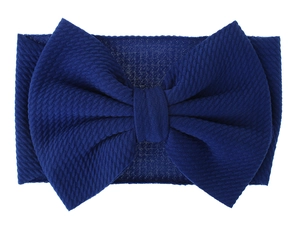 Close-up of navy blue waffle knit baby headband with a large oversized bow detail