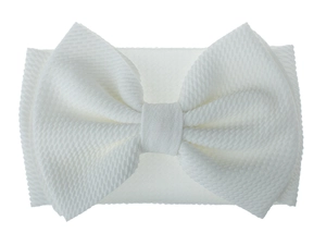 Detail of white waffle knit baby headband featuring an oversized fabric bow design