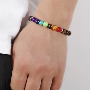 Chakra bead bracelet with natural tiger eye and turquoise stones on a person's wrist