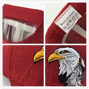 Detail view of red baseball cap with eagle embroidery and acrylic material label