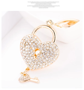Macro shot of gold heart-shaped padlock keychain with sparkling white rhinestones