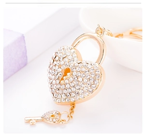 Macro view of gold heart padlock keychain set with sparkling white rhinestones and key