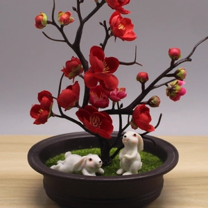 Miniature bonsai with cute resin rabbits and red plum blossoms for desktop decor