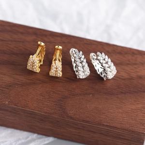 Detail shot of gold and silver wheat-shaped S925 silver earrings with sparkling crystals