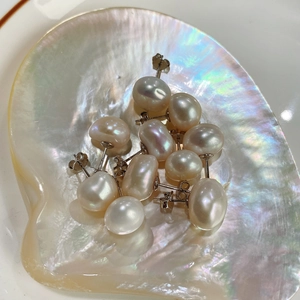 Baroque pearl stud earrings in 925 sterling silver displayed in a natural seashell