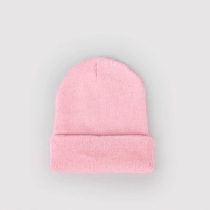 Dettaglio della trama a maglia fine e del bordo a costine di un berretto rosa invernale