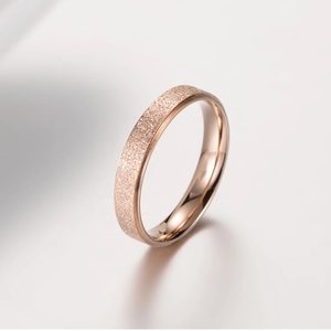 Gros plan d'une bague en or rose avec finition givrée et intérieur poli brillant