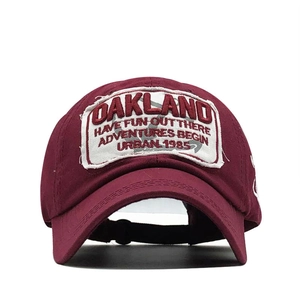Front view of vintage burgundy cotton baseball cap with Oakland embroidery on white background