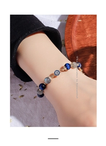 Detailed view of beaded bracelet with blue moonstone, grey labradorite and evil eye charm