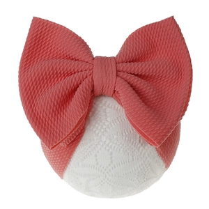 Detail of coral pink waffle fabric baby headband with white floral lace and large bow