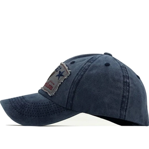 Détail de la casquette de baseball en coton bleu marine délavé avec écusson d'étoile brodée