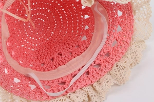 Detail of pink straw hat inner lining showing the sweatband and elastic chin strap
